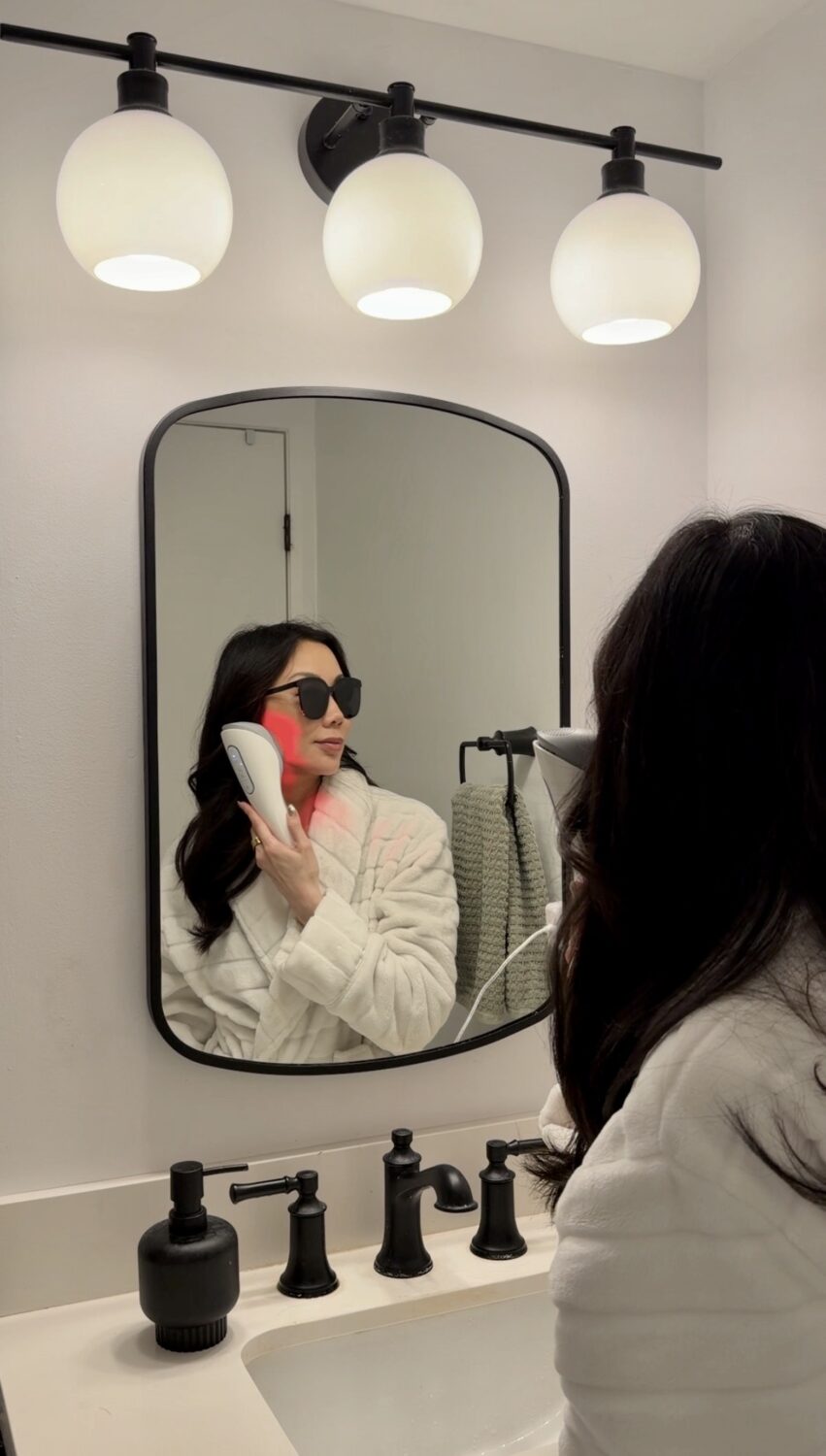 Lumirea photofacial device in use on jawline — sapphire cooling tip against skin